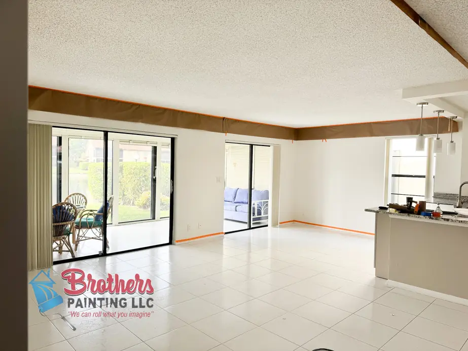 Condo living room with brown masking paper and orange tape along the ceiling line